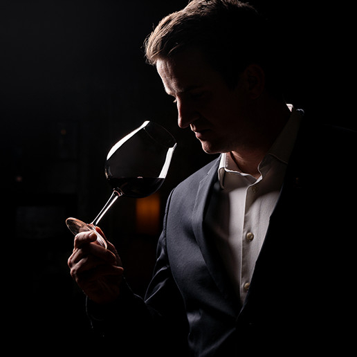 Мужчина, вдыхающий аромат вина в ресторане Dans le Noir?